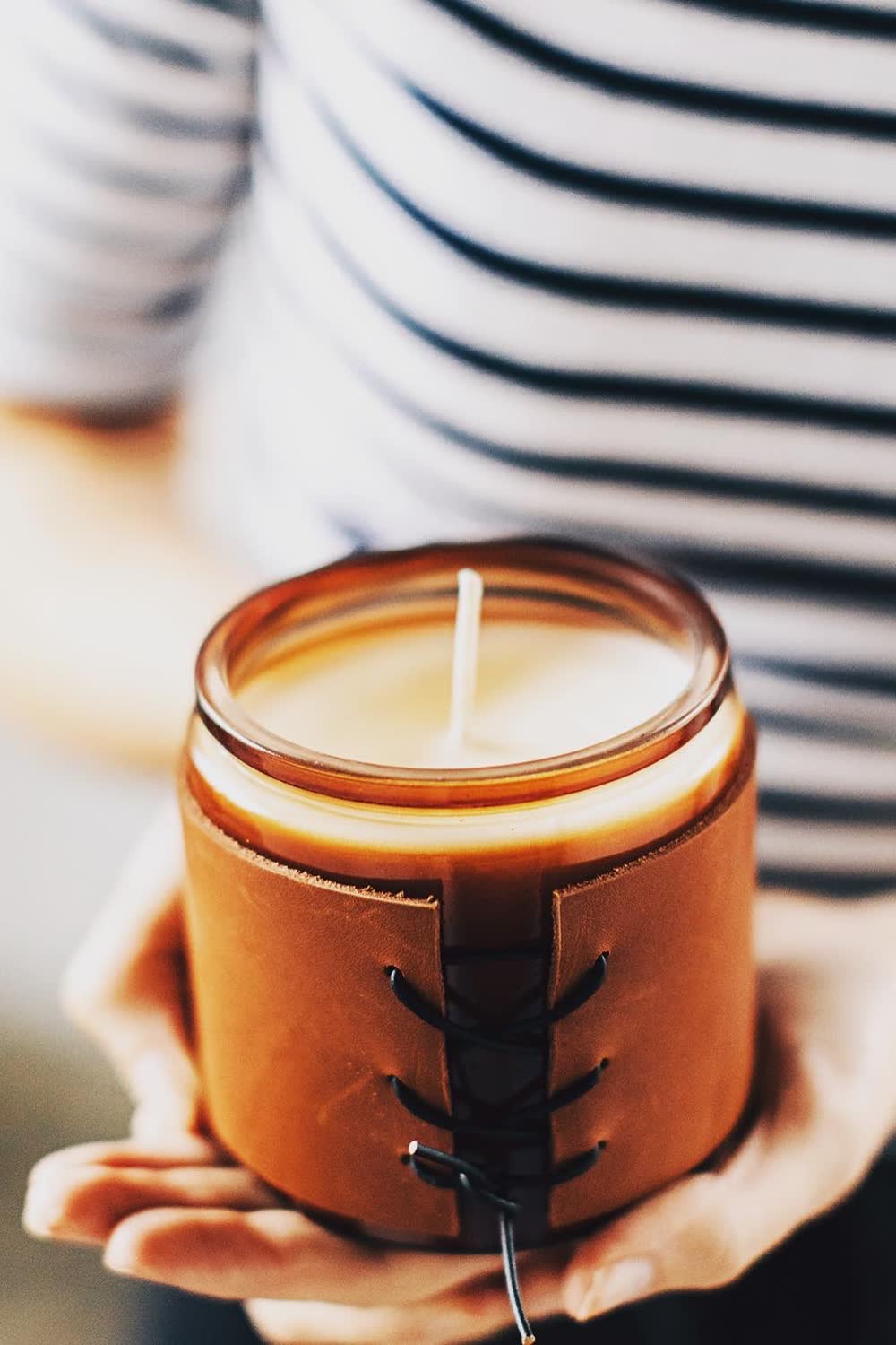 A guest holding a finished leather-wrapped Wick Bar candle.