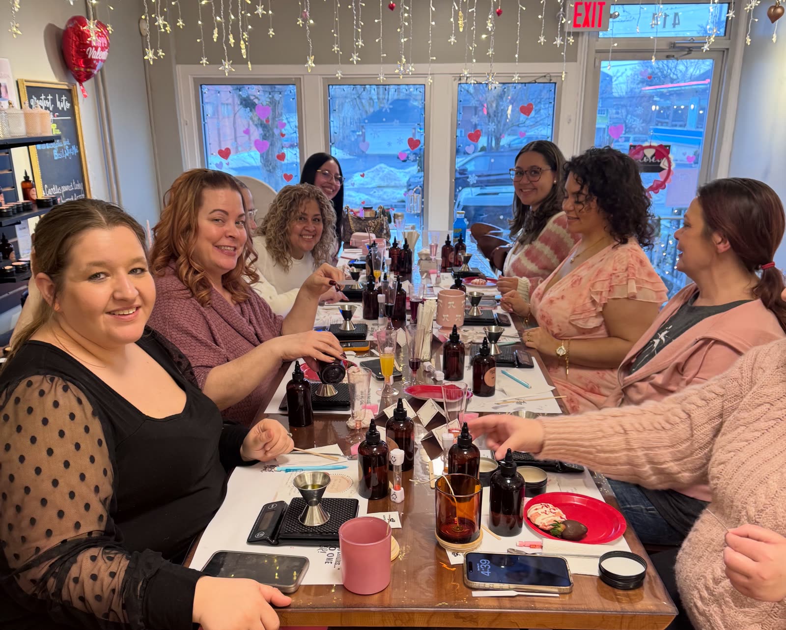 A bride and her friends around the Wick Bar table, blending their scents.