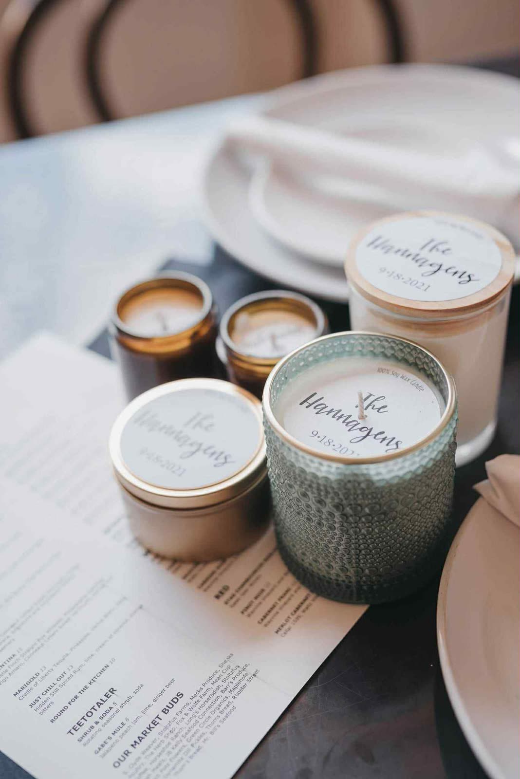 Custom “The Hannigans” wedding favor candles on a reception table.