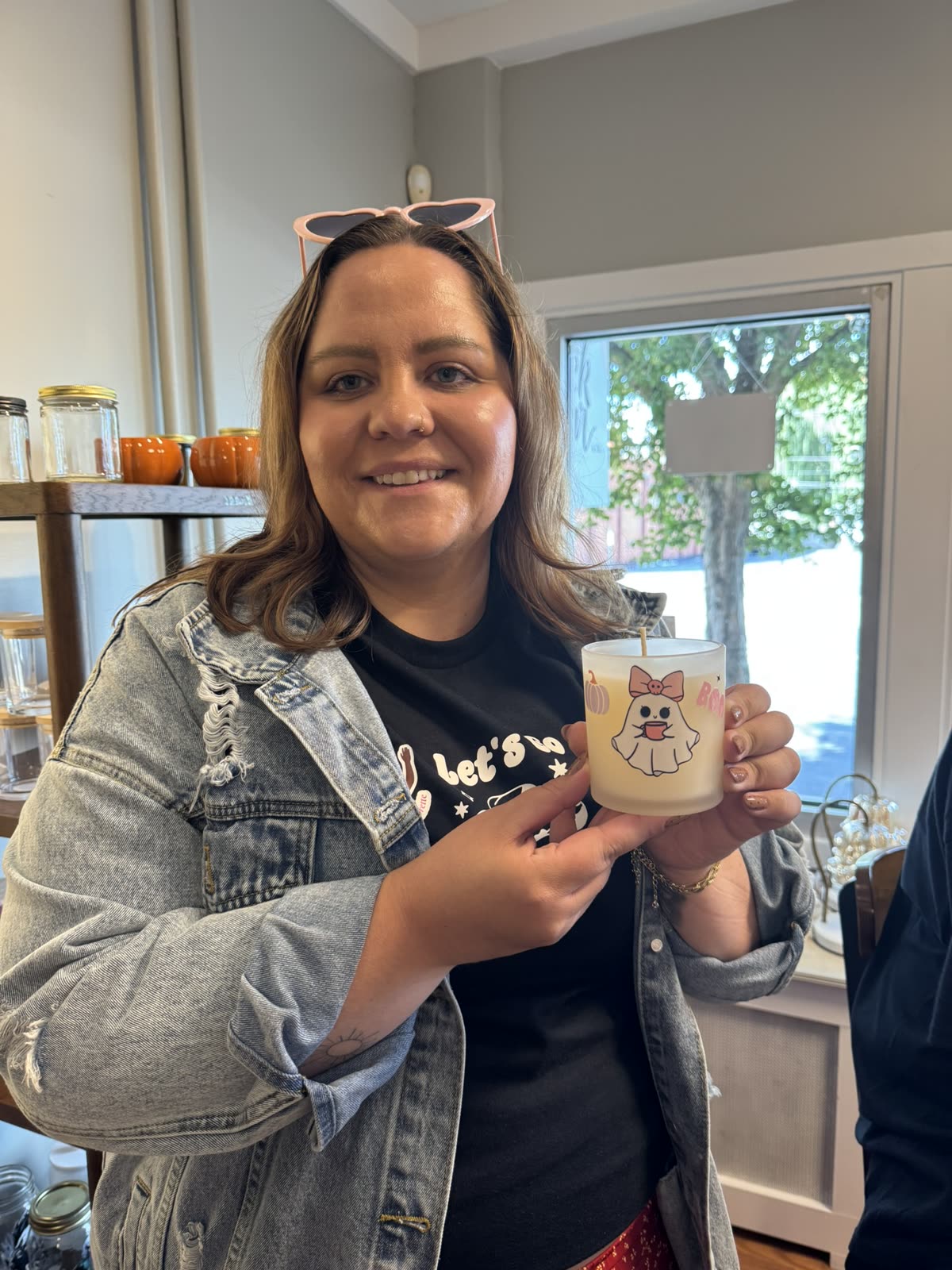 A smiling bachelorette guest holding up her decorated candle.